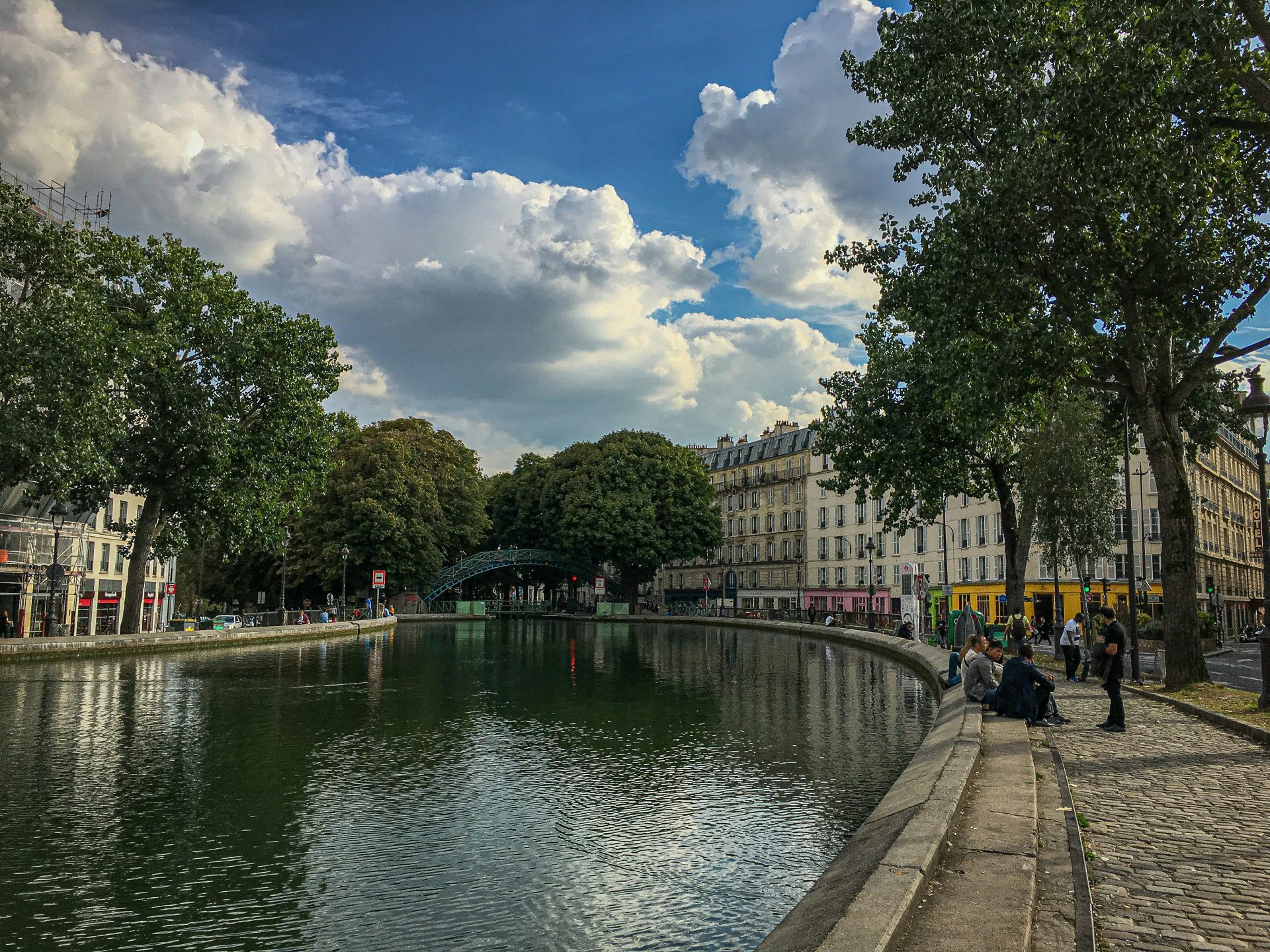 people walking on sidewalk near river during daytime